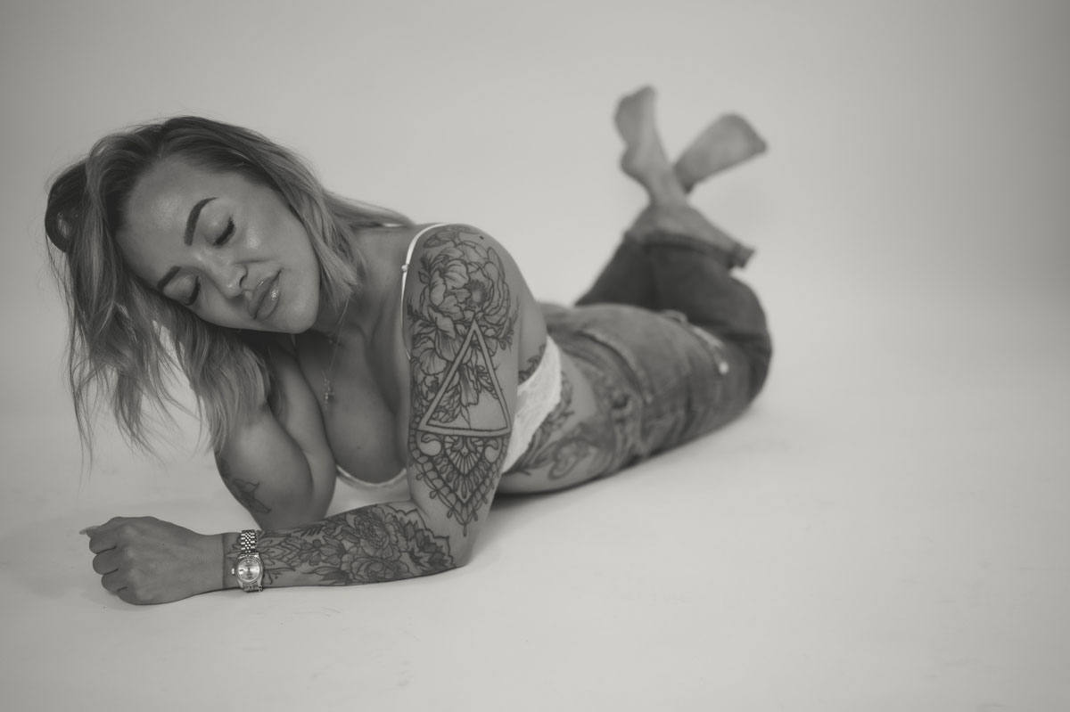 The coach is posing while laying down on the floor.